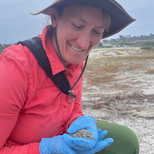 Closeup of Erica Mills out in field holding a bird.