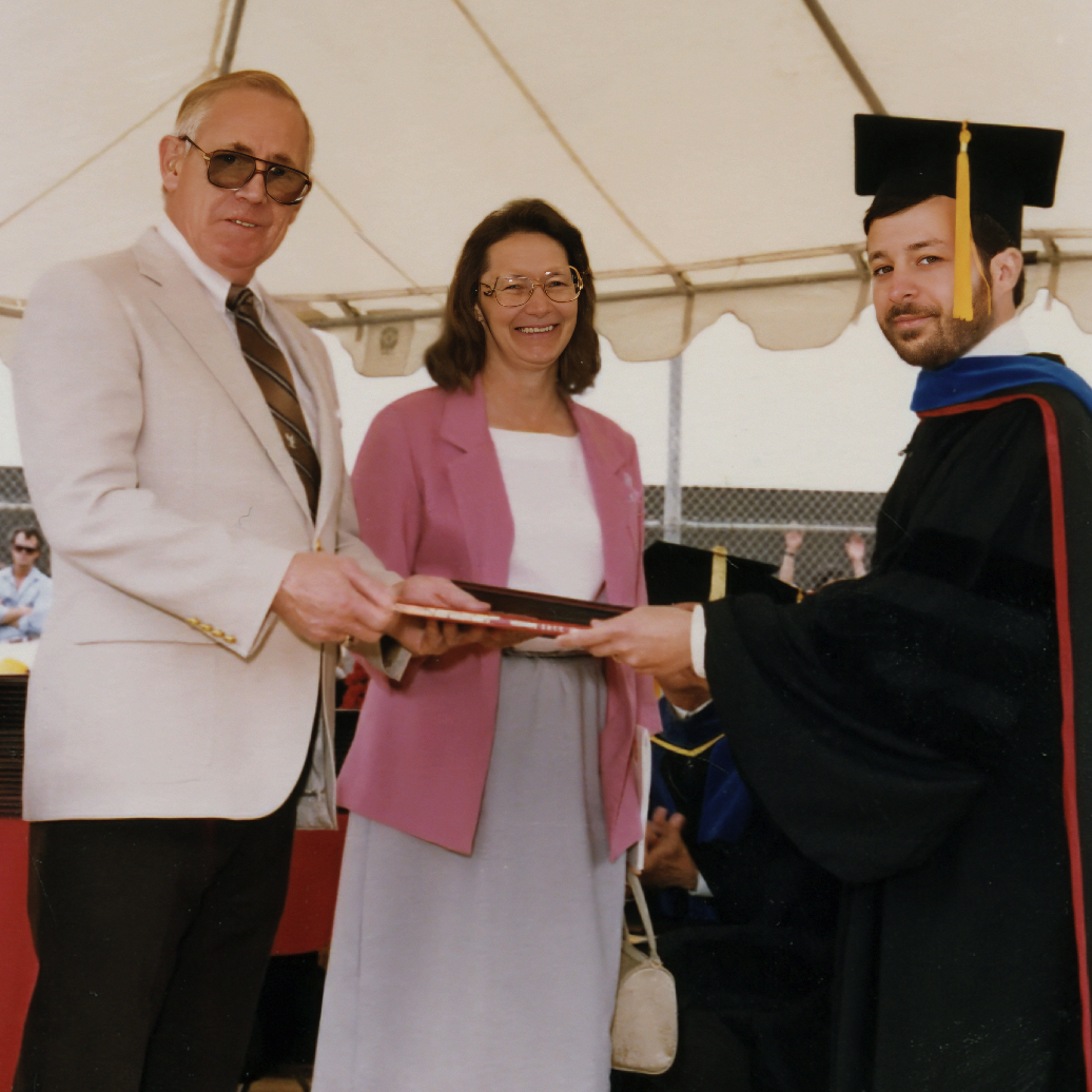 Sandy Bernstein handing diploma to Mr. & Mrs.Wassenberg.