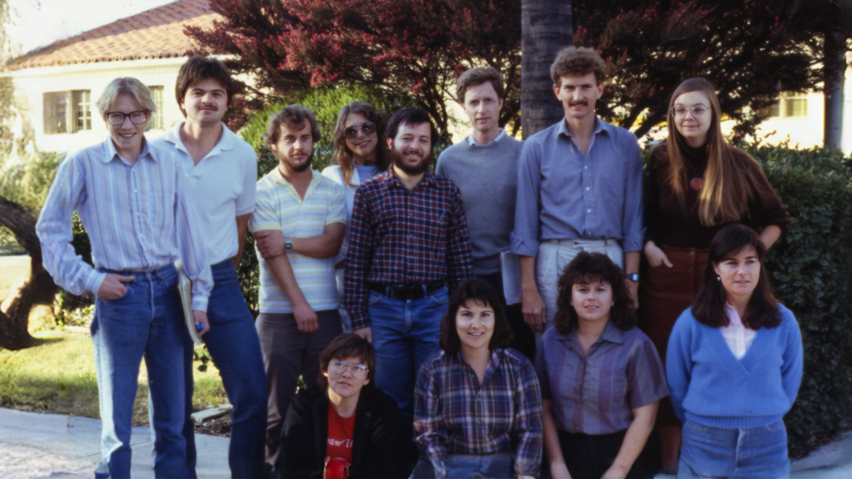 12 people pose for photo outdoors, circa 1985.